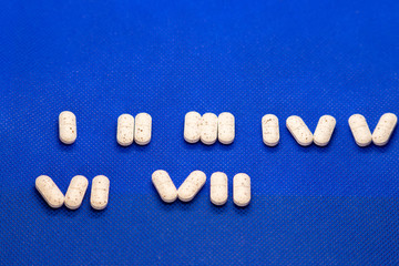 Many white medicine tablets on blue background. White pills, concept – pharmacy. Medicines drugs.