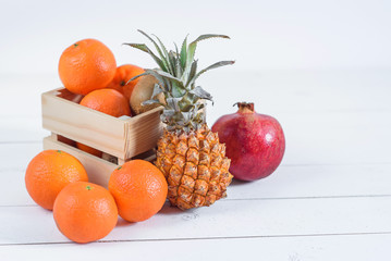 Group of fresh tropical fruits in small wooden box.