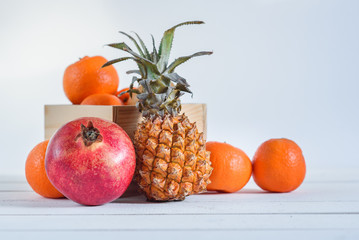 Group of fresh tropical fruits in small wooden box.