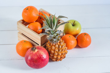 Group of fresh tropical fruits in small wooden box.
