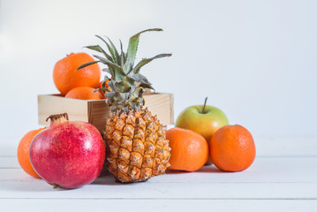 Group of fresh tropical fruits in small wooden box.
