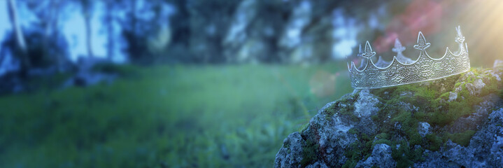 mysterious and magical photo of silver king crown over the stone covered with moss in the England...