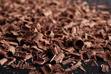 Pile of tasty chocolate curls on black background, closeup