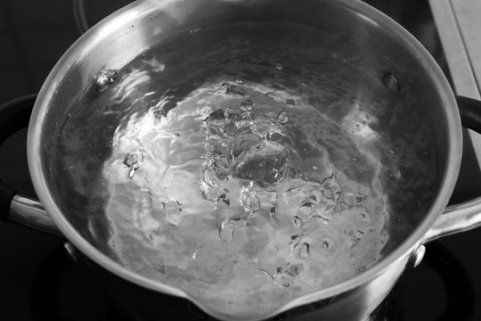 Pot with boiling water on stove, closeup