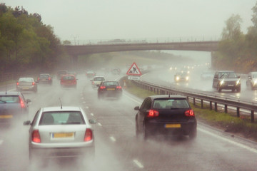 Traffics on a rainy wet highway in fog water spray - 244579716