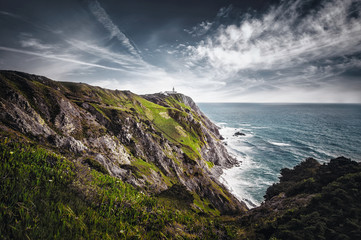 beautiful Atlantic ocean view horizon with lighthouse , flowers and rocks. Sintra,  Portugal