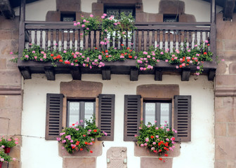 Fototapeta na wymiar Balconies with flowers on the facade of a house