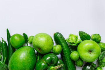 green fruits and vegetables on white background with copy space on top