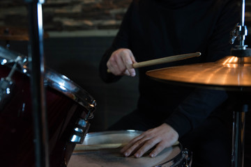 Professional drum set closeup. Drummer with drumsticks playing drums and cymbals, on the live music rock concert or in recording studio   