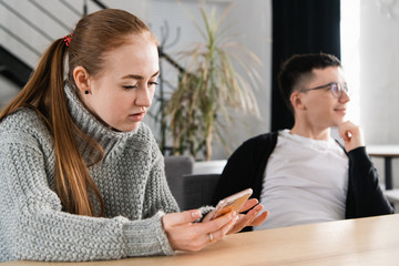 Fototapeta premium Woman reading her man's cheating messages on his phone