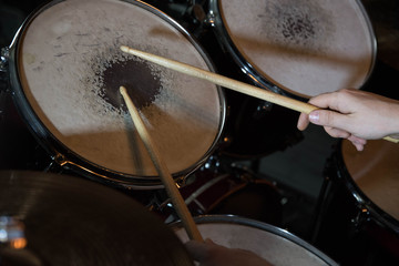 Professional drum set closeup. Drummer with drumsticks playing drums and cymbals, on the live music rock concert or in recording studio   