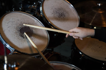 Fototapeta na wymiar Professional drum set closeup. Drummer with drumsticks playing drums and cymbals, on the live music rock concert or in recording studio 