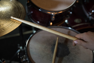 Professional drum set closeup. Drummer with drumsticks playing drums and cymbals, on the live music rock concert or in recording studio   