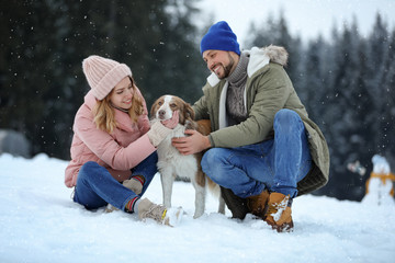 Naklejka premium Cute couple with dog near forest. Winter vacation