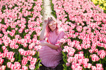 Smiling girl sitting in Tulip field