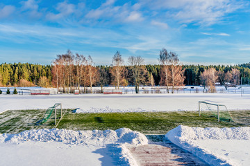 Empty Football (Soccer) Field in the Winter Partly Covered in Snow - Sunny Winter Day