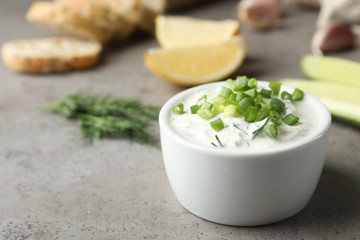 Cucumber sauce in ceramic bowl on table, space for text. Traditional Tzatziki