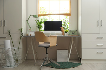Light work place with computer near window at home. Interior design