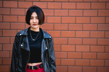 Naklejka premium Portrait of beautiful asian chic girl pose for take a picture on wall background,Lifestyle of teen thailand people,Modern woman happy concept,Punk rock style