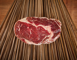 Raw Ribeye Steak on a wood backdrop 