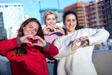 Heart shape from three friends women hands.