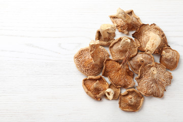 Dried mushrooms on wooden background, top view. Space for text