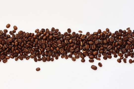 Roasted coffee beans on white background © Olesia