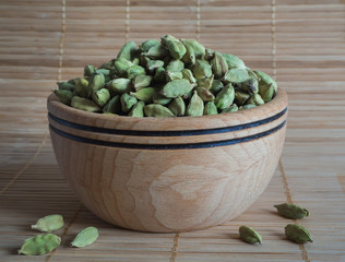 Cardamom in a wooden bowl.
