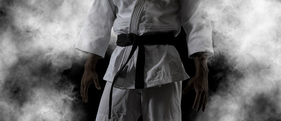 Guy poses in white kimono with black belt.  Black retouch © Andrey Burmakin