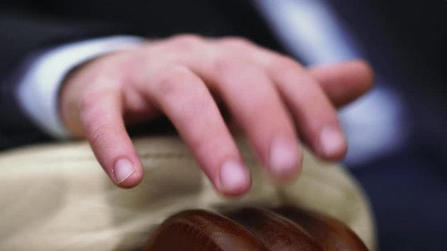 Hand of man is lying on armrest. Gentleman drumming his fingers