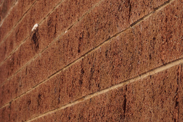 The texture of a brick wall made of blocks of imitation of natural stone, a delightful background with a gradient.         