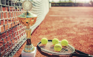 Tuinposter Tennis balls with a racket and cup on the tennis court. Sport, recreation concept © bobex73