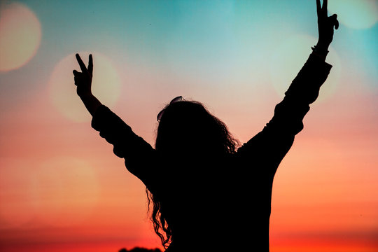 Silhouette einer gl&uuml;cklichen Frau im Abendrot