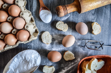 eggs flour and bread on mader background...