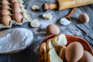 eggs flour and bread on mader background...