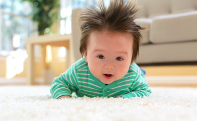 Fototapeta premium Happy smiling newborn baby boy playing on the carpet