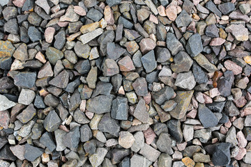 Grey stone chippings lying on the ground outdoors. Natural background texture.