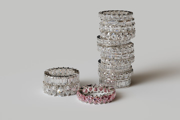 Stacked various diamond eternity rings on white background