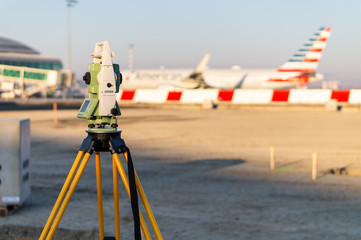 Surveyor equipment (theodolite) on construction site of the airport, building or road with...