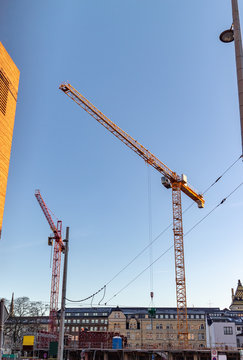 Baustelle eines modernen B&uuml;ro,Bank und Gesch&auml;ftshaus mit Einr&uuml;stung und Abst&uuml;tzungen und zei Kr&auml;nen vor blauen Himmel