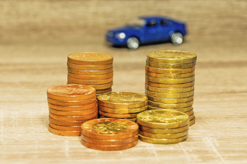 Car model and coin on a wooden table as a concept of buying or renting a car. Loan for buying a car. Czech money at the table. Financial concept with money. Golden coins.