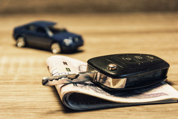 Car keys, banknotes and car model as the concept of buying or renting a car. Loan for buying a car. Czech money at the table. Financial concept with money.