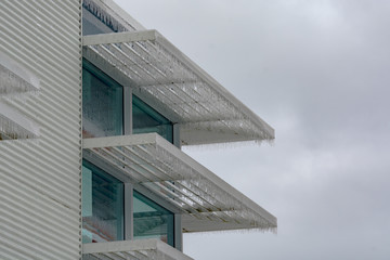 Icicles of freezing rain over window weather shelds of an office building in British Columbia, Canada