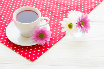 Black tea ceremony - a cup of tea, teapot, sugar, cakes, flowers on a red with white dots background