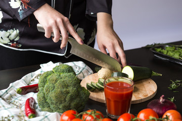 girl cuts vegetables with a knife in the kitchen