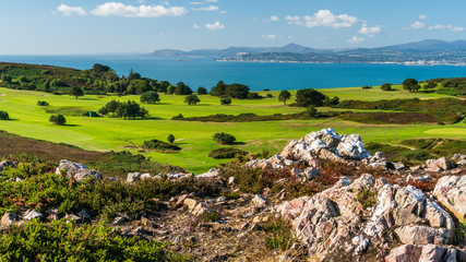 Colourful landscape with rocks, green grass and blue sea on a beautiful summer day. View over a...