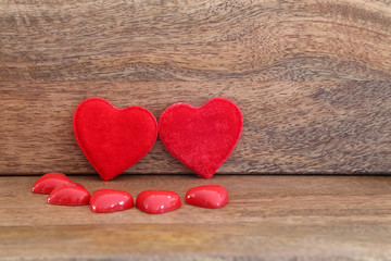 Two red hearts surrounded by smaller hearts against wooden background, Valentine's Day 