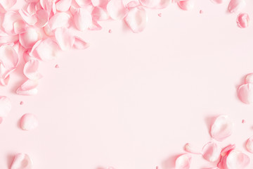 Bloemen samenstelling. Roze bloemblaadjes op pastel roze achtergrond. Valentijnsdag, moederdag, vrouwendagconcept. Platliggend, bovenaanzicht, kopieerruimte