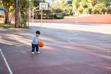 Child with his ball on the basketball court
