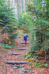 Old woman wandering on a mountain trail